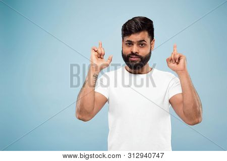 Half-length Close Up Portrait Of Young Hindoo Man In White Shirt On Blue Background. Human Emotions,