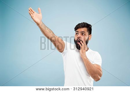 Half-length Close Up Portrait Of Young Hindoo Man In White Shirt On Blue Background. Human Emotions,
