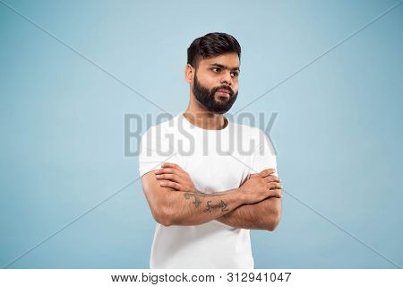 Half-length Close Up Portrait Of Young Hindoo Man In White Shirt On Blue Background. Human Emotions,