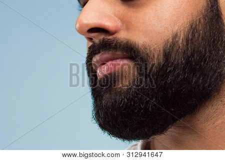 Close Up Portrait Of Young Hindoo Mans Face With Beard And Lips On Blue Background. Looking Calm. Hu