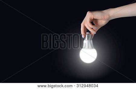 Illumination. Glowing Bulbt In Female Hand.  The Search With Light In The Dark Room Concept.
