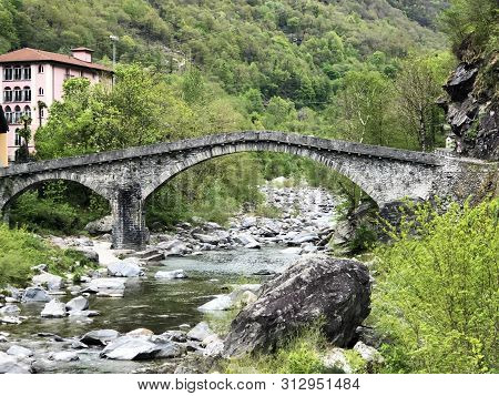 An Old Stone Bridge Over The Maggia River In The Village Of Bignasco (the Maggia Valley Or Valle Mag