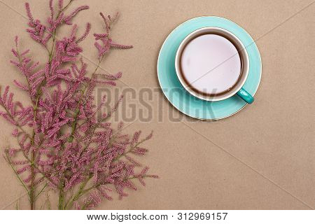 Cup Of Hot Tea And A Tamarix Gallica Tree Branches On A Brown Background.