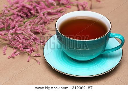 Cup Of Hot Tea And A Tamarix Gallica Tree Branches On A Brown Background.