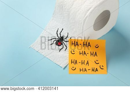 Toilet Paper Roll With Drawn Spider And Words Ha-ha  On Light Blue Background. Celebrating April Foo