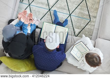 Top view of young muslim family reading Quran during Ramadan