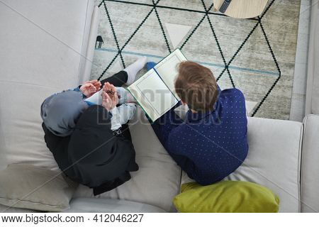 Top view of young muslim family reading Quran during Ramadan