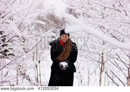 Beautiful Sexy Girl Tosing Snow. Around The Trees In The Snow