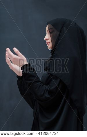 Portrait of young Muslim woman making dua