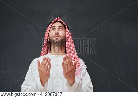 Arab man in traditional clothes praying to God or making dua