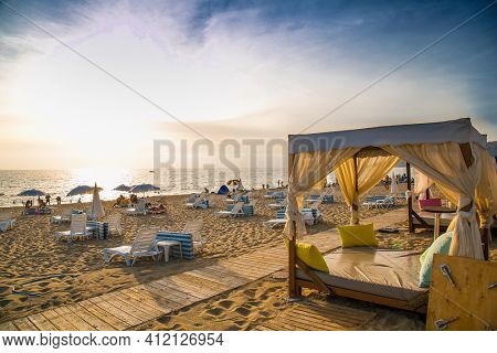 Alanya, Turkey -October 20, 2020: Luxury wood framed whit  curtains for relaxing on the sandy Kleopatra beach in Alanya,  Turkey.