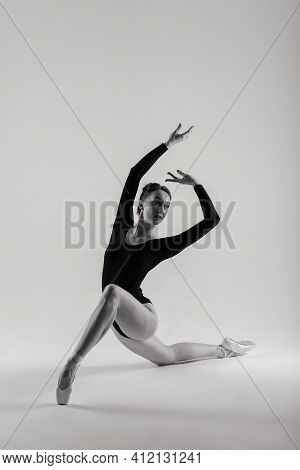 Portarit Of Sensual Professional Caucasian Callet Dancer In Body Suit And Pointes Shoes On White.