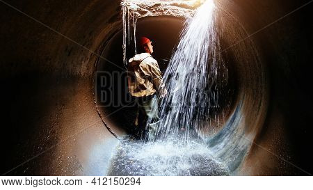 Sewer Tunnel Worker Examines Sewer System Damage And Wastewater Leakage.