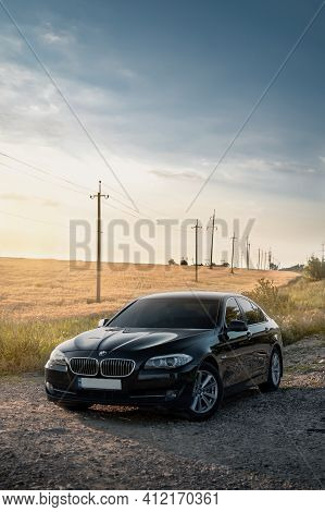 Kherson, Ukraine - June 2019. Bmw 5-series F10 In A Black Color In The Field.