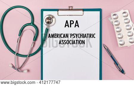 Paper With Apa American Psychiatric Association On The Office Desk, Stethoscope And Pills, Top View