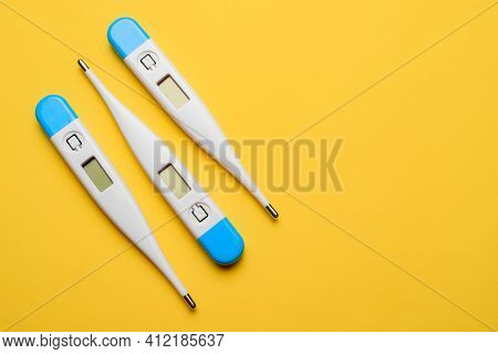 Electronic Thermometers . Electronic Thermometer On A Yellow Background. Temperature Measurement. Sa