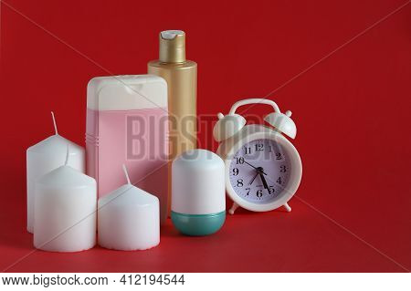Set For Spa Treatments And Stearin Candles On A Red Background. Time For Hygiene Procedures