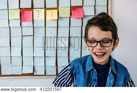 Autism Awareness Funny Concept. Portrait Of Cheerful Autism Boy With Glasses In Blue Shirt Front A B