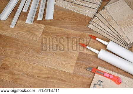 Set Of Items For Pvc Ceiling Indoor Works. Assembly Adhesive Bottles And Pvc Panels With Plastic Cor