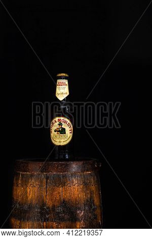 Bottle Of Birra Moretti Beer On Wooden Barrel With Dark Background. Illustrative Editorial Photo Buc