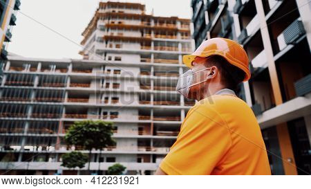 Topic Is Health Protection In Production And Construction. Caucasian Male Worker In Orange Uniform A