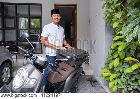 Male Muslim Pack His Suitcase On His Motorbike Getting Ready To Travel During Eid Mubarak