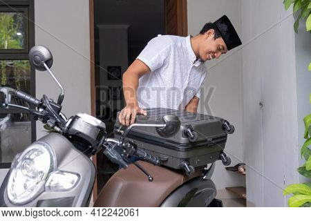 Male Muslim Pack His Suitcase On His Motorbike Getting Ready To Travel During Eid Mubarak