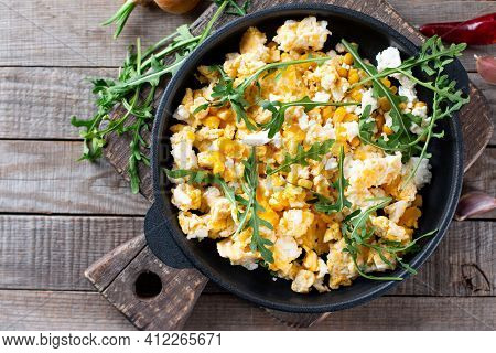 Fresh Scrambled Eggs With Corn, Cheese, Herbs And Vegetable On A Wooden Table, Top View. Delicious H