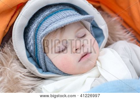 Toddler chłopiec w zimowe ubrania, spanie w wózek