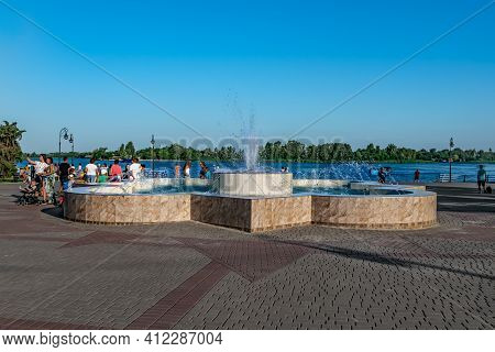 Kherson, Ukraine - July 22, 2020: The Fountain On The Waterfront In Kherson. People Walk On The Prom