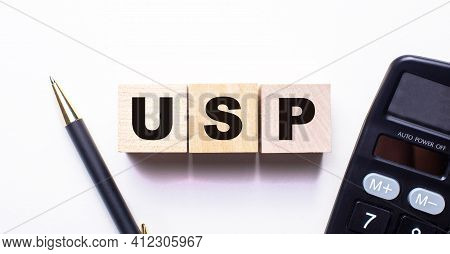 The Words Usp Unique Selling Proposition Is Written On Wooden Cubes Between A Pen And A Calculator O