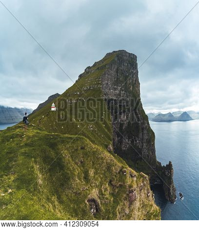 Kalsoy Island With Kallur Lighthouse On On Faroe Islands, Denmark, Europe. Clouds Over High Cliffs, 