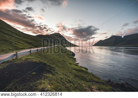 Faroe Islands Kalsoy In Sunset Light Durig Twilight With Pink Sky And Cliffs.