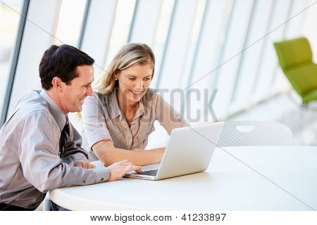 Obchodní lidé mají schůzku kolem stolu v moderní kancelářské