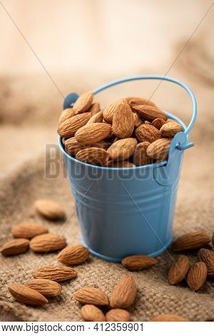 Almonds In Blue Bucket
 On Wooden Table. Almond Concept With Copyspace.