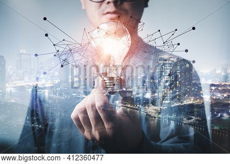 Double Exposure Of Businessman Holding Light Bulb. Idea Concept With Innovation And Inspiration Crea