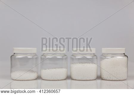 Transparent Bottle Inside With Plastic Beads. White Polymer. White Plastic Beads.