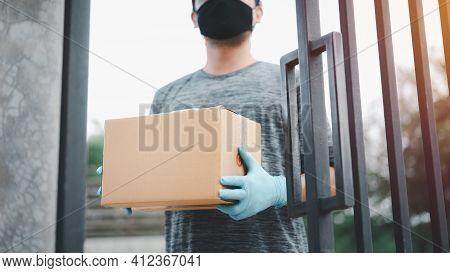 New Normal Life Style. Home Delivery Shopping Box Man Wearing Gloves And Protective Mask Delivering 