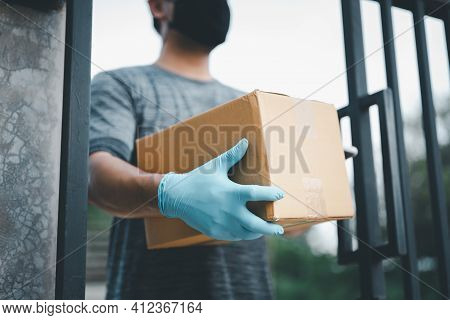 New Normal Life Style. Home Delivery Shopping Box Man Wearing Gloves And Protective Mask Delivering 