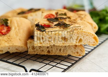 Slice Of Chopped Focaccia, Pizza, Cut Flat Bread With Vegetables On Grid, Tradition Italian Cuisine.