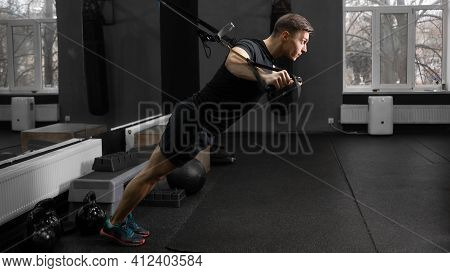 A Fit Man Works Out In The Gym On The Simulator, Shakes The Muscles Of The Arms And Back, Does Exerc
