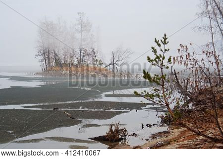 Ice In Peaceful Calm Still Water Along The Lake Near A Pine Tree Forest