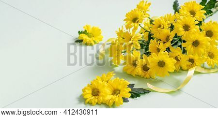 Yellow Chrysanthemums Bouquet With Yellow Ribbon On The Turquoise Background. Festive Yellow Chrysan