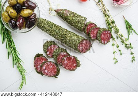 Traditianal Fuet Sausage In Herbs With Ingredients On White Surface, Top View.