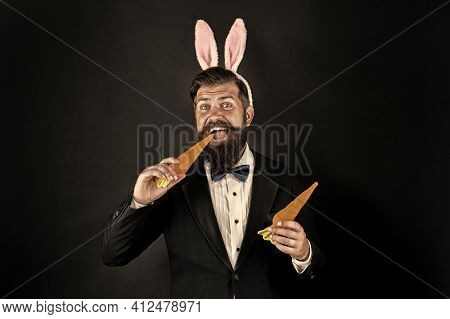 Here Comes Easter Bunny. Bearded Man With Bunny Ears Eat Carrots. Bunny Costume Accessory. Symbol Of