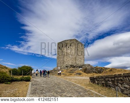 Guarda, Portugal; August 2020: Stone Squared Tower Over Rocky Hill With Lawn And Deserted Pathway, O