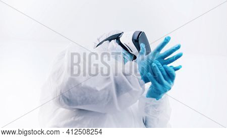 African American Black Doctor In Protective Uniform And With Vr Glasses Putting On Gloves. High Qual