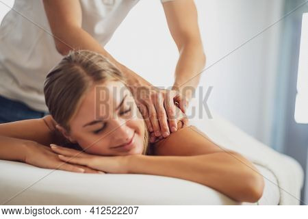 Professional Masseur Doing Therapeutic Massage. Woman Enjoying Massage In Her Home. Young Woman Gett