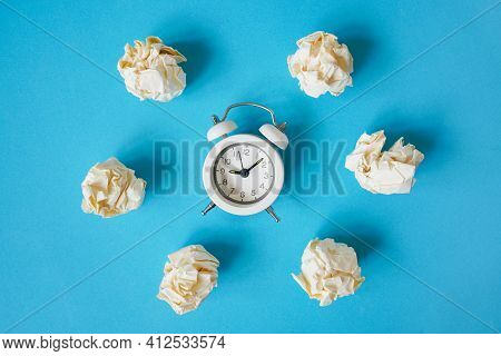 Crumpled Paper Balls Around White Alarm Clock On Grunge Blue Paper Background For Business , Deadlin