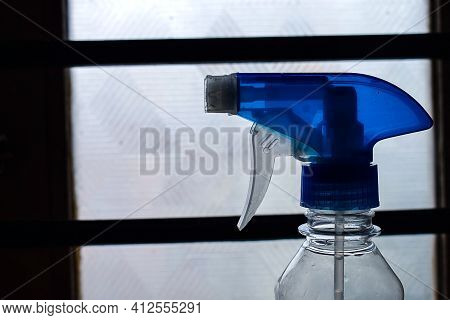 Stock Photo Of A Blue Color Trigger Pistol Spray Bottle Kept In Front Of Window Used For Cleaning Pu